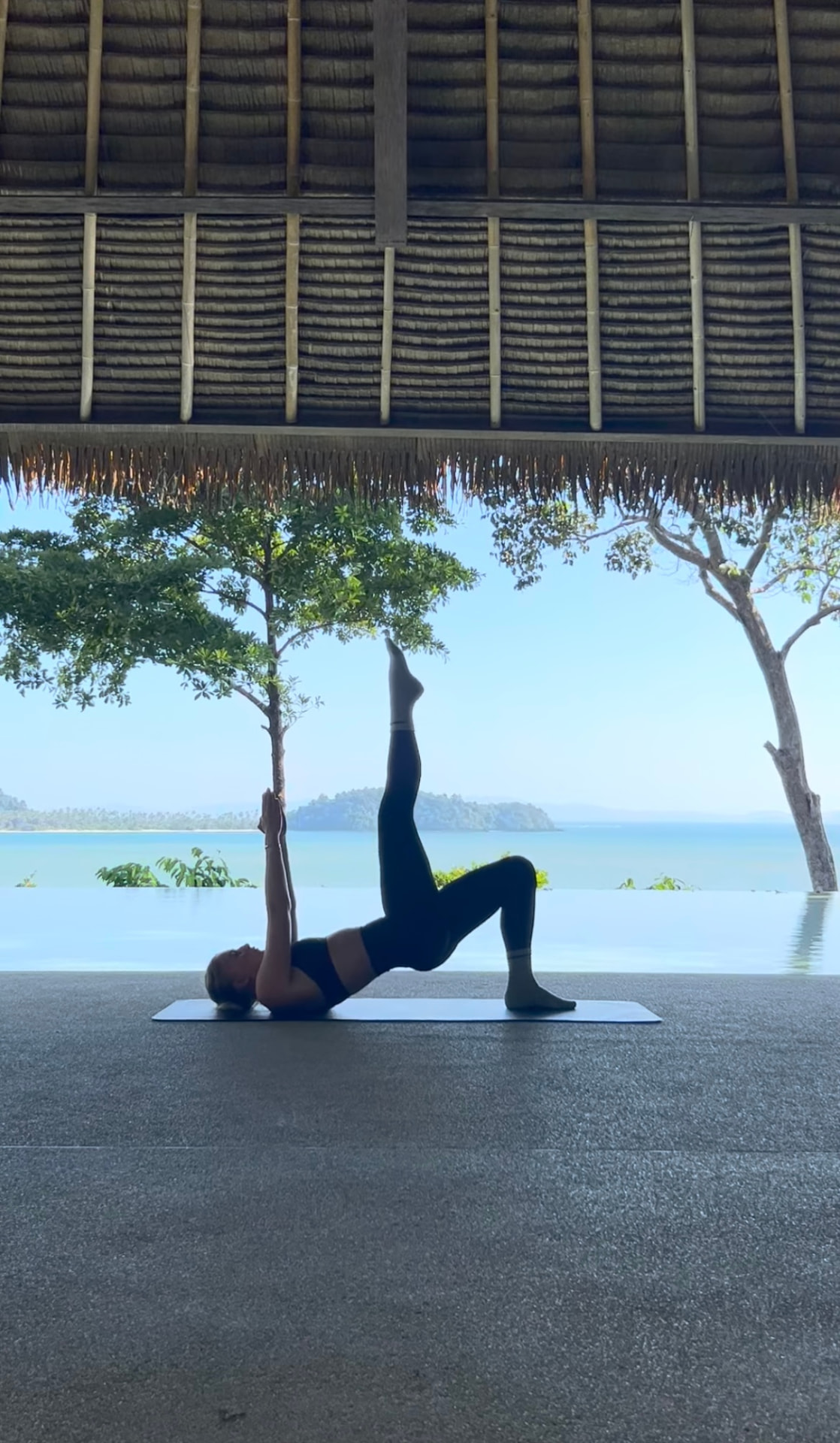 Frederikke Adamsen in a Pilates bridge pose outdoors by the water